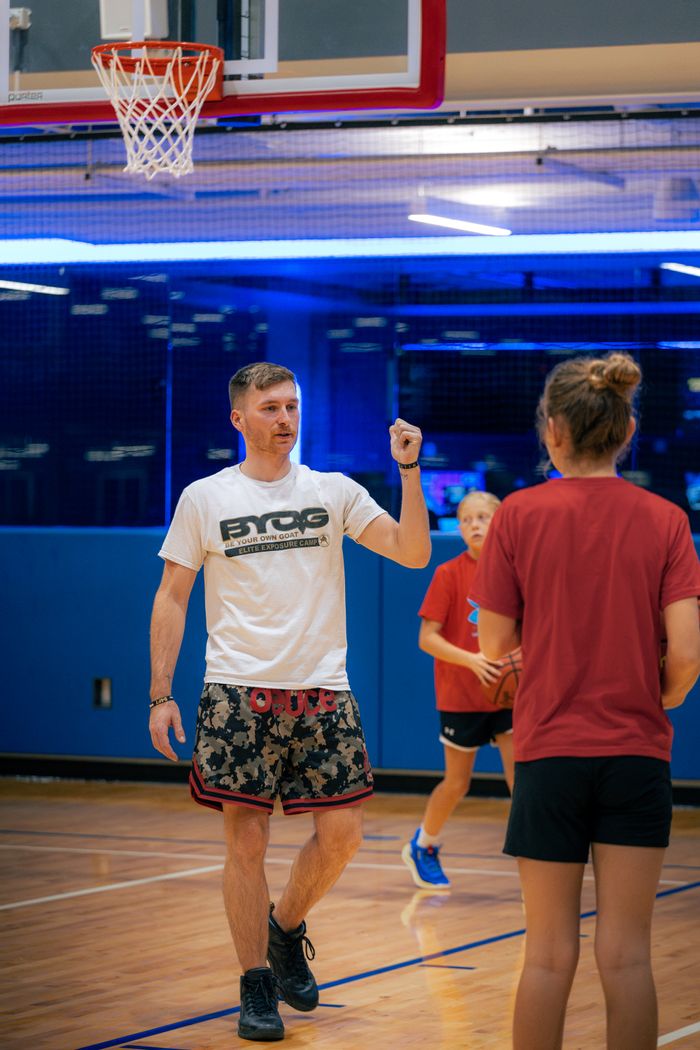 Coach guiding a young athlete through a dribble drill